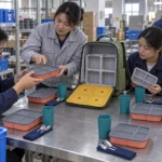 Adult chaperone distributing reusable dining sets at a park table